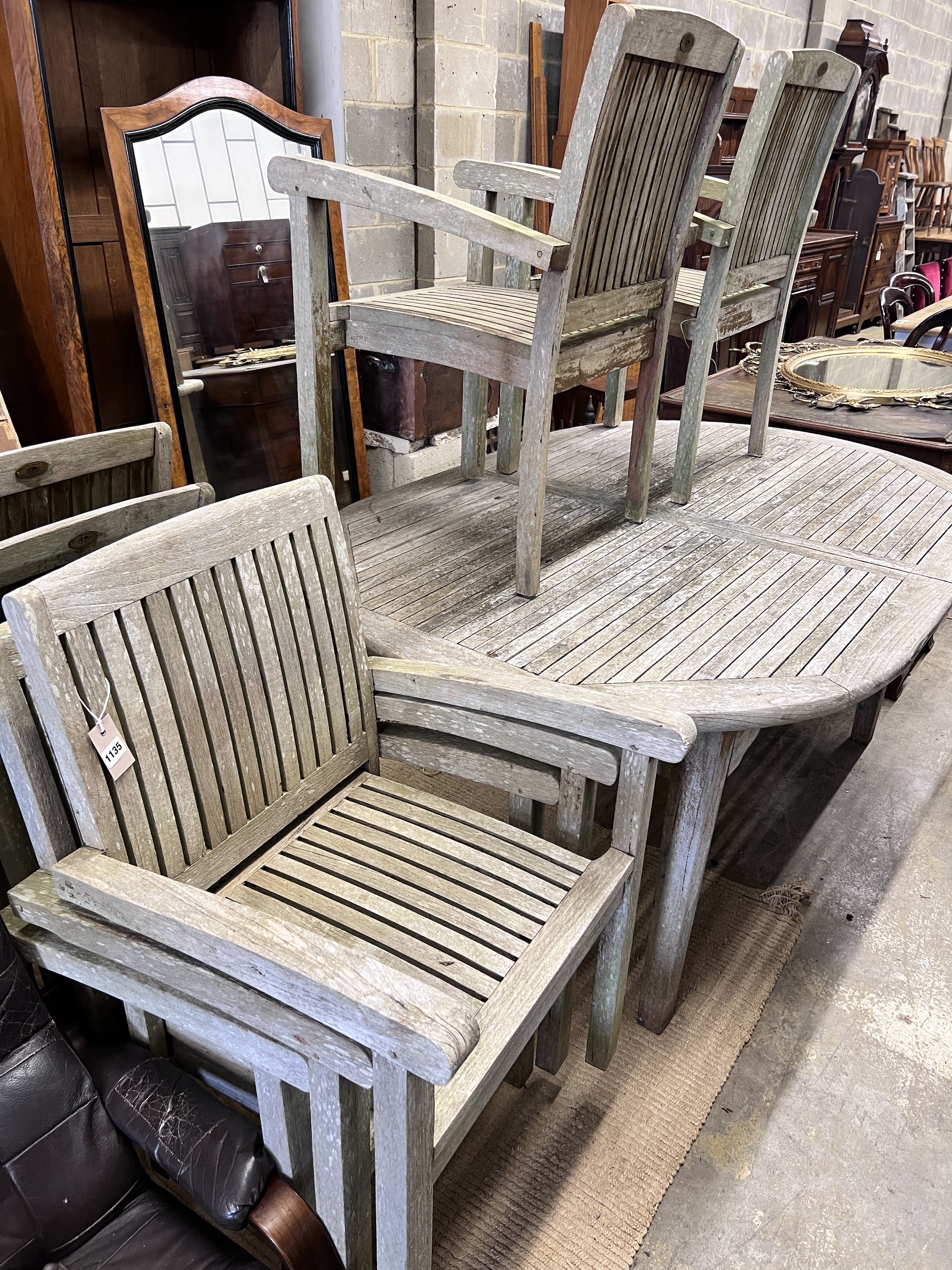 A Hard Woodstock Ltd. weathered teak extending garden table and eight matching stacking chairs